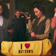Angela Bassett, Karen Gillan, Michelle Yeoh, and Carla Gugino examine a variety of guns in a library with an "I love kittens" duffel bag in front of them.